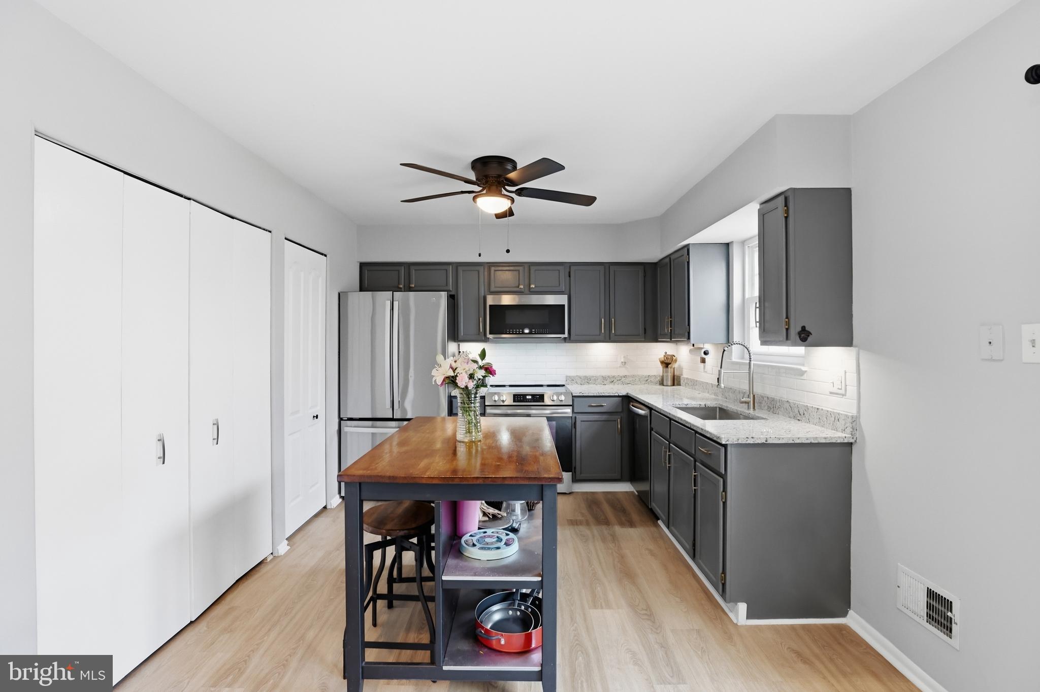 6844 Carnation Circle Frederick, MD 21703 - Photo 12 of 30 a kitchen with stainless steel appliances a stove a sink and a refrigerator with wooden floor