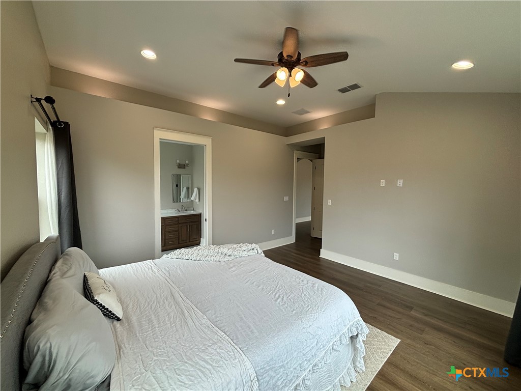 110 Hiram Cook Blanco, TX 78606 - Photo 38 of 46 a bedroom with a large bed and a chandelier