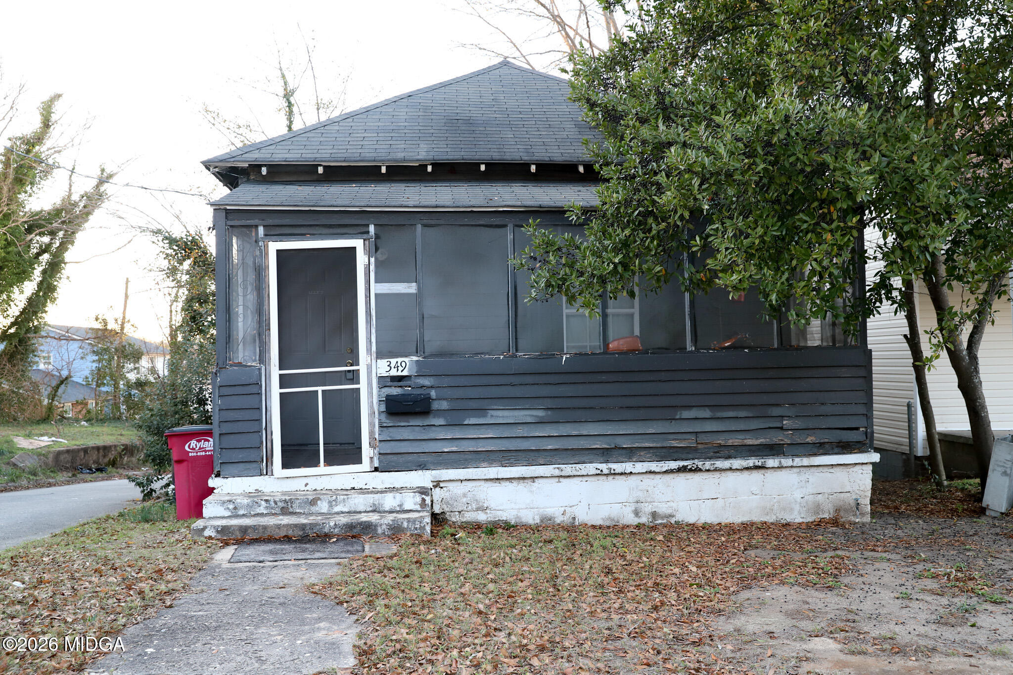 a view of a house with a yard and large tree