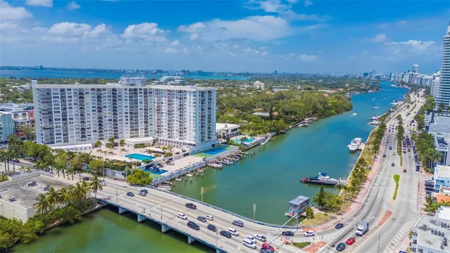 an aerial view of residential houses with yard and lake view in back