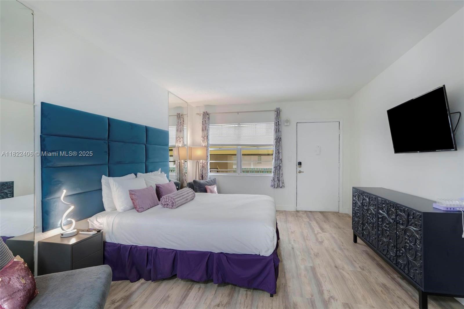 4015 Indian Creek Drive, Unit 106 Miami Beach, FL 33140 - Photo 5 of 29 a bedroom with a bed and a flat screen television