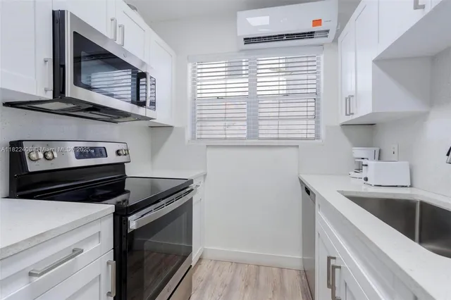 a kitchen with appliances cabinets and a sink