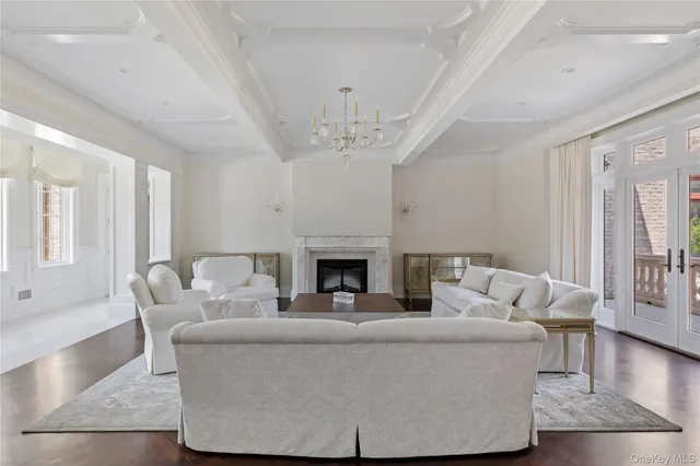 a living room with furniture a large window and wooden floor