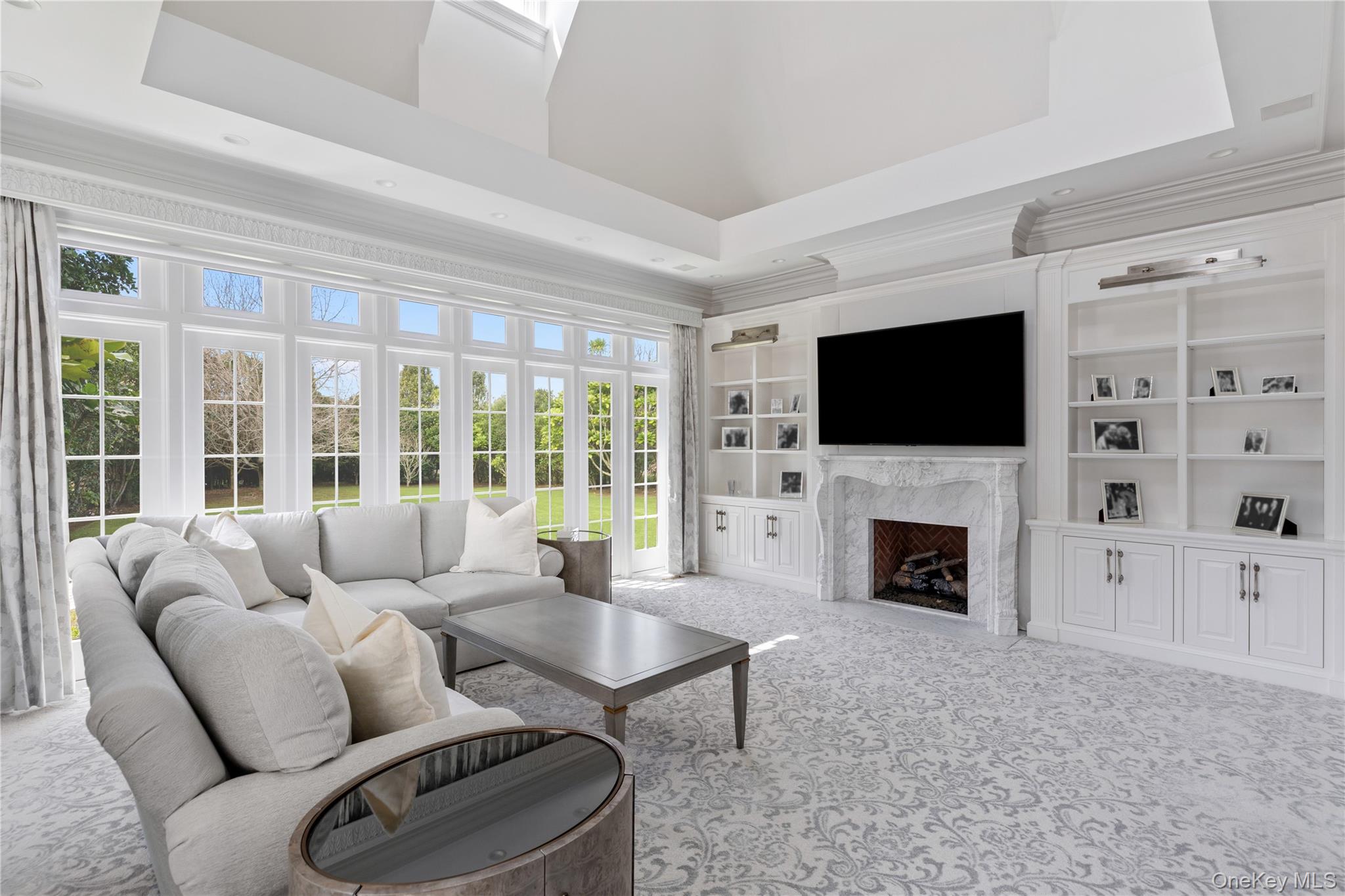 9 Hicks Lane Sands Point, NY 11050 - Photo 22 of 45 a living room with furniture a fireplace and a flat screen tv