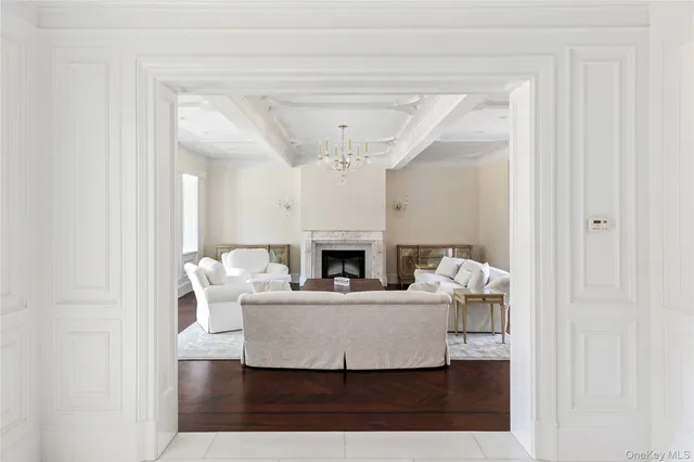 a living room with furniture a fireplace and a chandelier