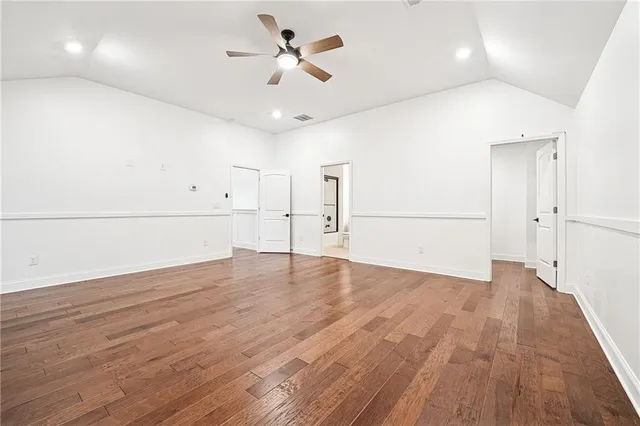 a view of empty room with wooden floor and ceiling fan