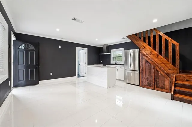a view of an empty room with kitchen view and a window
