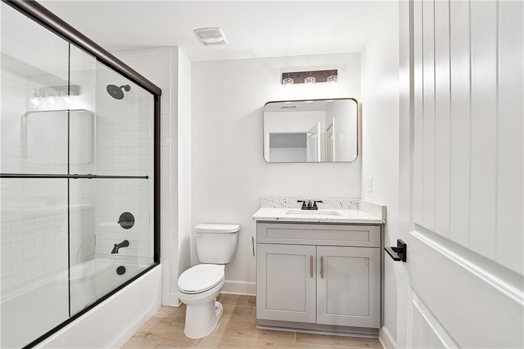 4603 Clarks Bridge Road Gainesville, GA 30506 - Photo 34 of 40 a bathroom with a toilet a sink a mirror a vanity and shower
