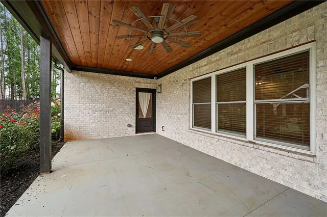 a view of porch with a table and chairs and floor to ceiling window with wooden fence
