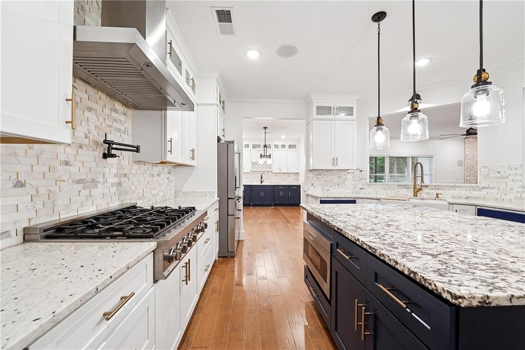 4603 Clarks Bridge Road Gainesville, GA 30506 - Photo 6 of 40 a kitchen with stainless steel appliances granite countertop a stove a sink dishwasher and white cabinets with wooden floor