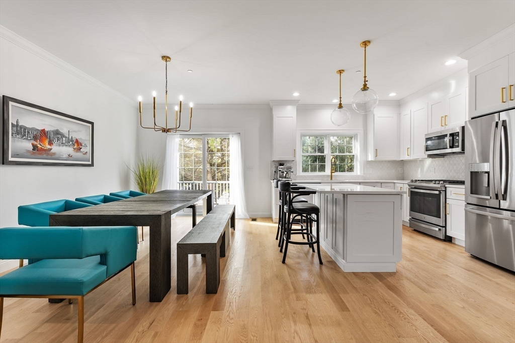 68 Prospect Street, Unit 14 Peabody, MA 01960 - Photo 3 of 29 a kitchen with stainless steel appliances granite countertop a refrigerator a stove a sink dishwasher a dining table and chairs with wooden floor