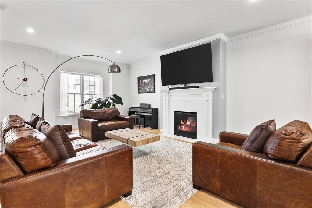 68 Prospect Street, Unit 14 Peabody, MA 01960 - Photo 6 of 29 a living room with fireplace furniture and a flat screen tv