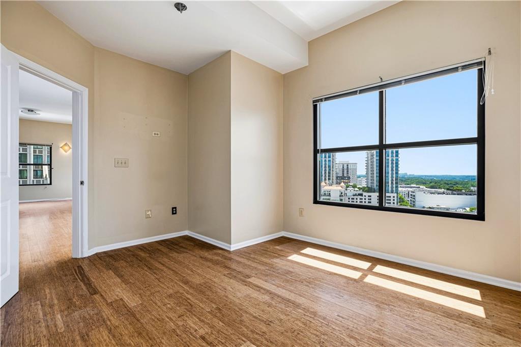 3040 Peachtree Road Northwest, Unit 1503 Atlanta, GA 30305 - Photo 32 of 38 an empty room with wooden floor and windows
