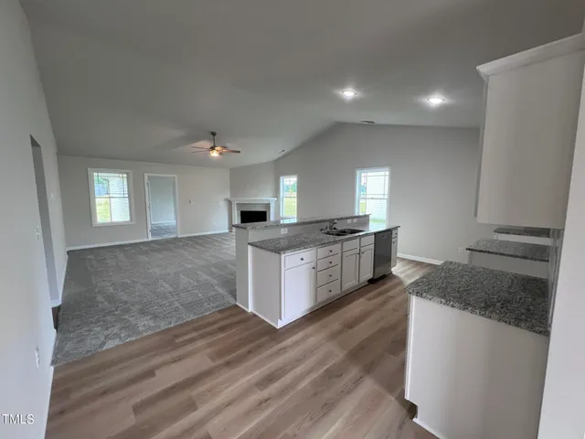 a large kitchen with kitchen island granite countertop a large counter top space and stainless steel appliances