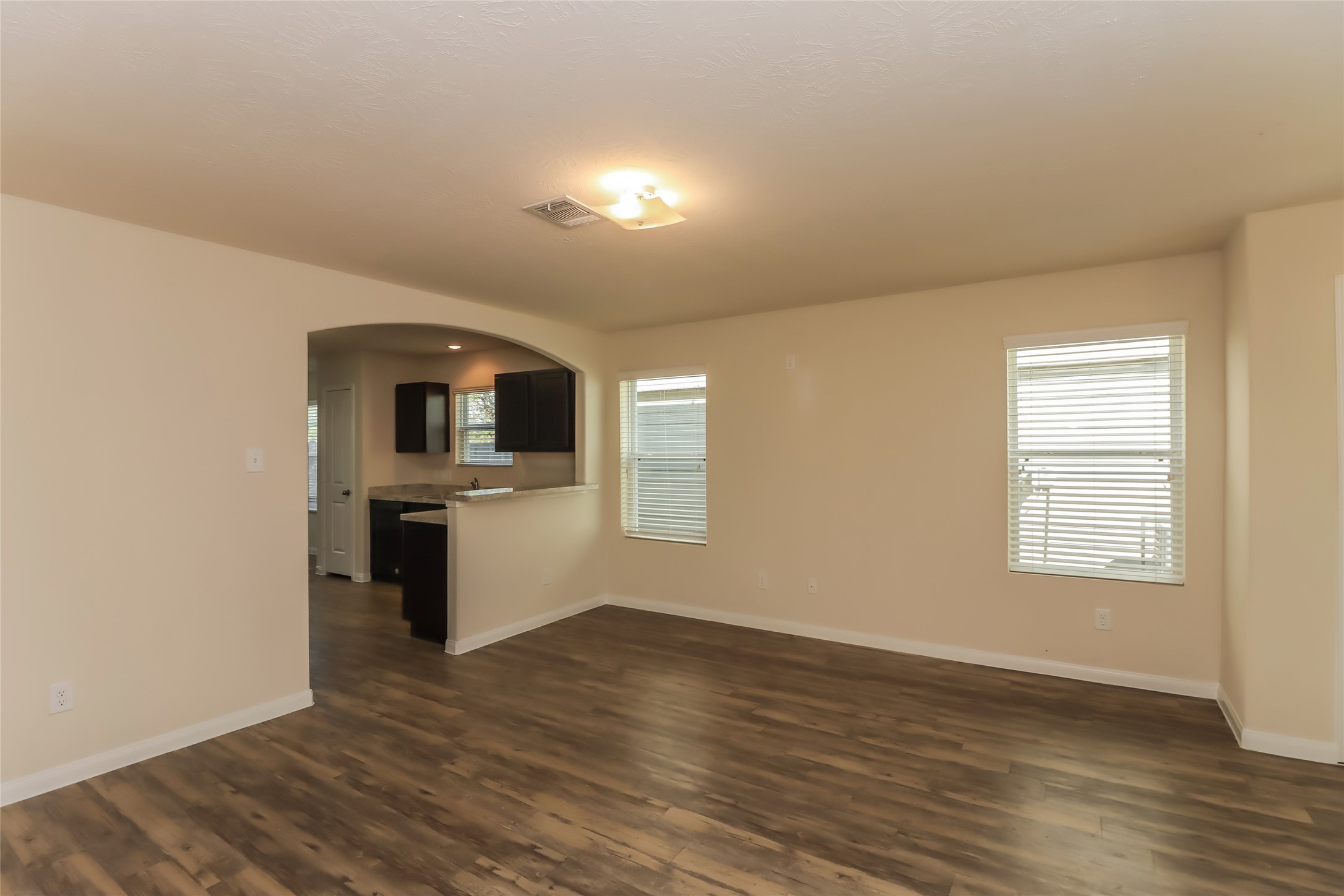 25751 Hazy Elm Lane Porter, TX 77365 - Photo 4 of 13 wooden floor in an empty room with a kitchen and a window