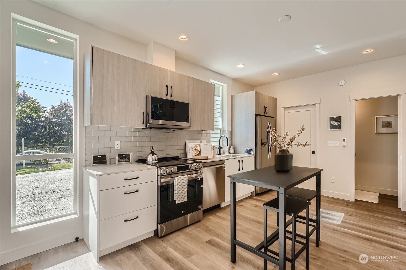 9524 3rd Avenue Northeast, Unit B Seattle, WA 98115 - Photo 4 of 21 a kitchen with stainless steel appliances kitchen island granite countertop a stove a sink dishwasher and a refrigerator with wooden floor