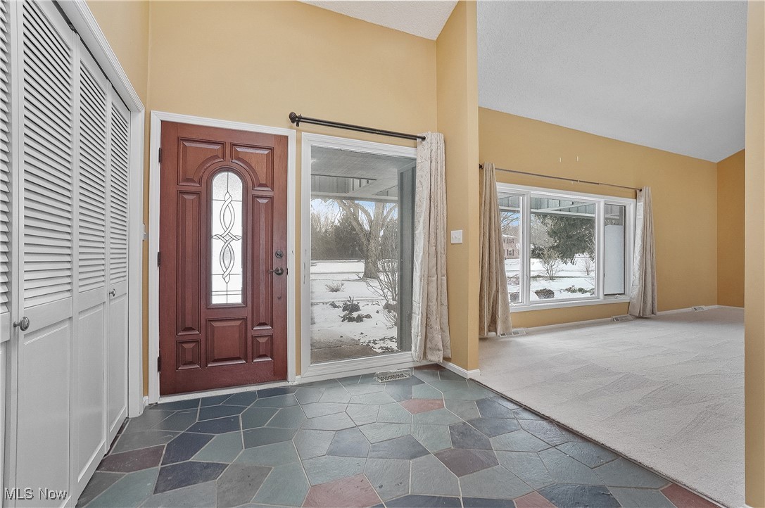 1094 San Raphael Drive Akron, OH 44333 - Photo 8 of 50 Entryway featuring lofted ceiling and dark stone finish floors