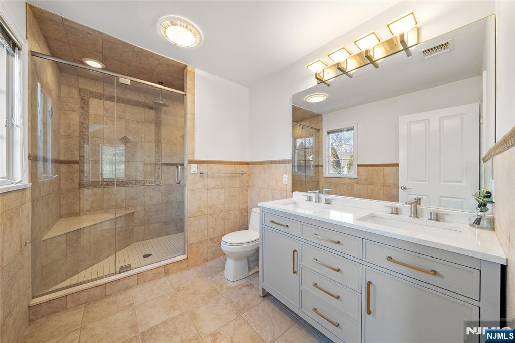 137 6th Street Cresskill, NJ 07626 - Photo 20 of 35 a bathroom with a double vanity sink toilet and shower
