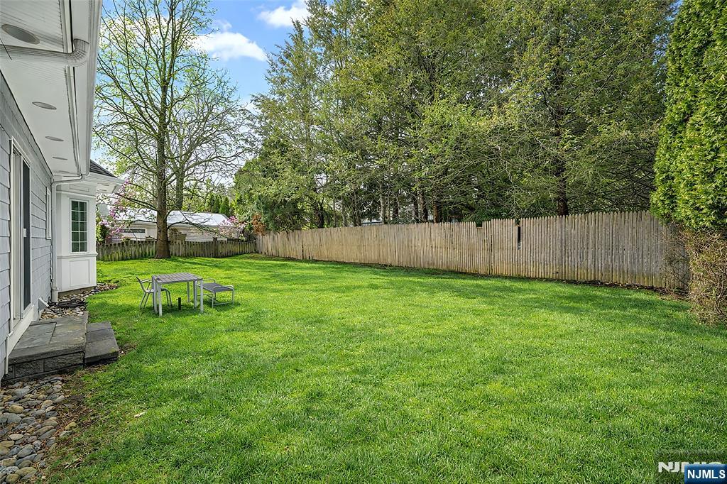 137 6th Street Cresskill, NJ 07626 - Photo 33 of 35 a view of a backyard with table and chairs and wooden fence