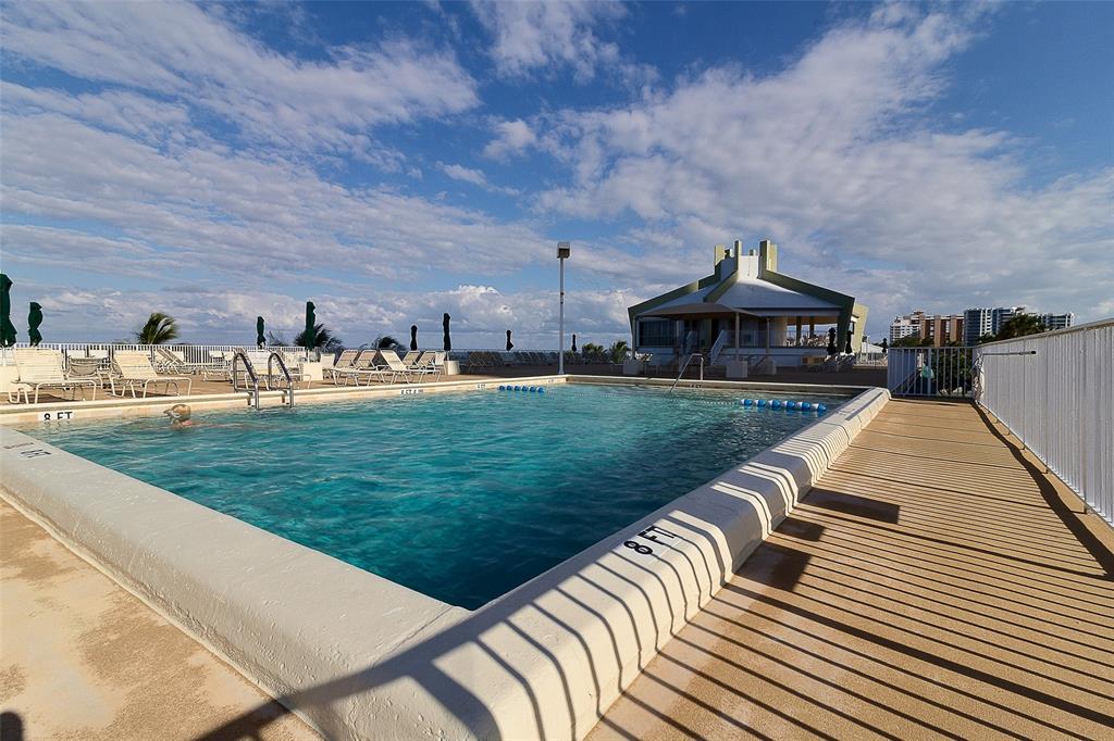 101 Briny Avenue, Unit 1606 Pompano Beach, FL 33062 - Photo 24 of 25 a view of swimming pool that has lawn chairs with wooden fence