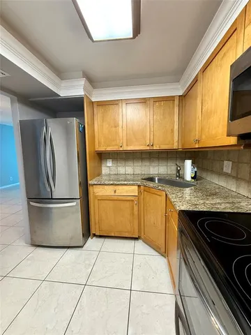 a kitchen with a stove a sink and a refrigerator
