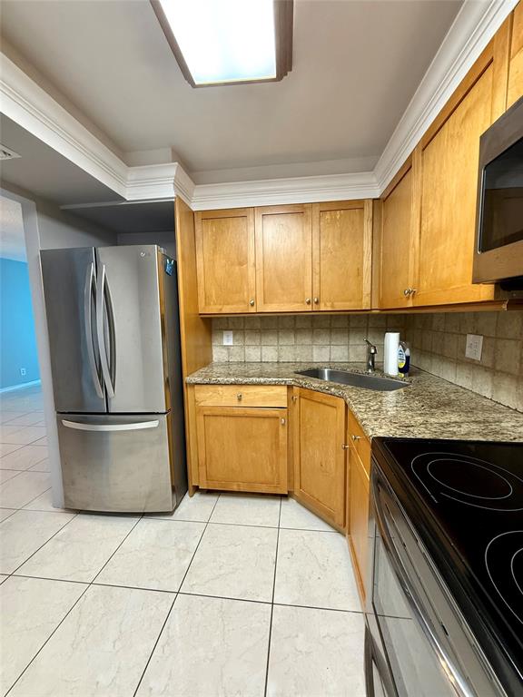 101 Briny Avenue, Unit 1606 Pompano Beach, FL 33062 - Photo 3 of 25 a kitchen with a stove a sink and a refrigerator