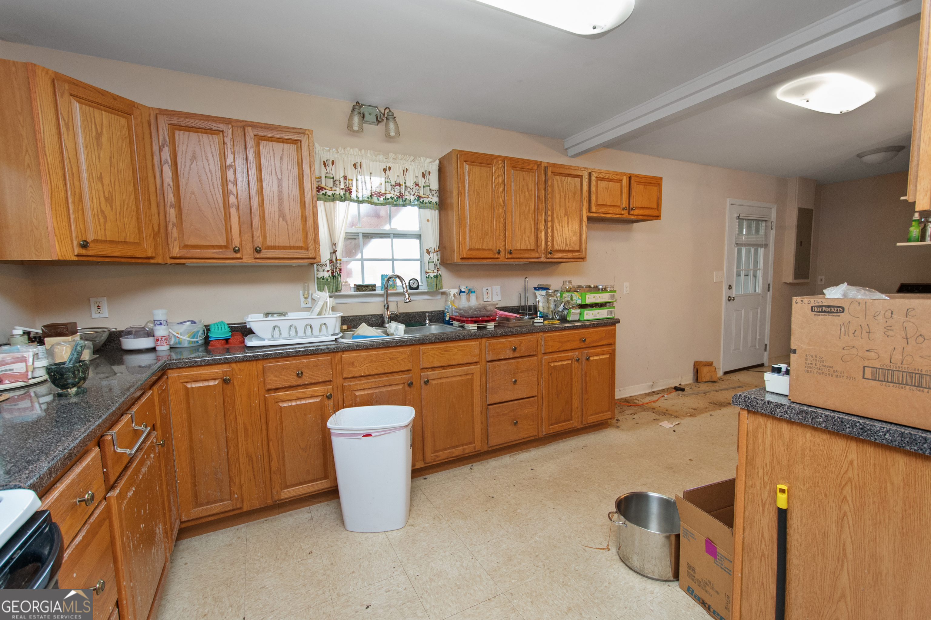 402 Tom Bell Road Milner, GA 30257 - Photo 40 of 64 a kitchen with wooden cabinets appliances a sink and a window