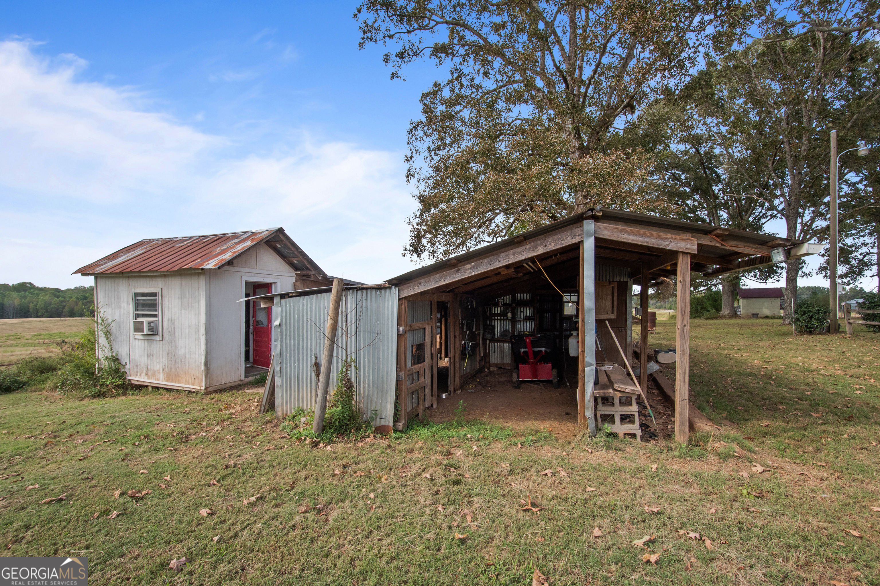 402 Tom Bell Road Milner, GA 30257 - Photo 54 of 64 a view of a wooden house with a large tree and wooden fence