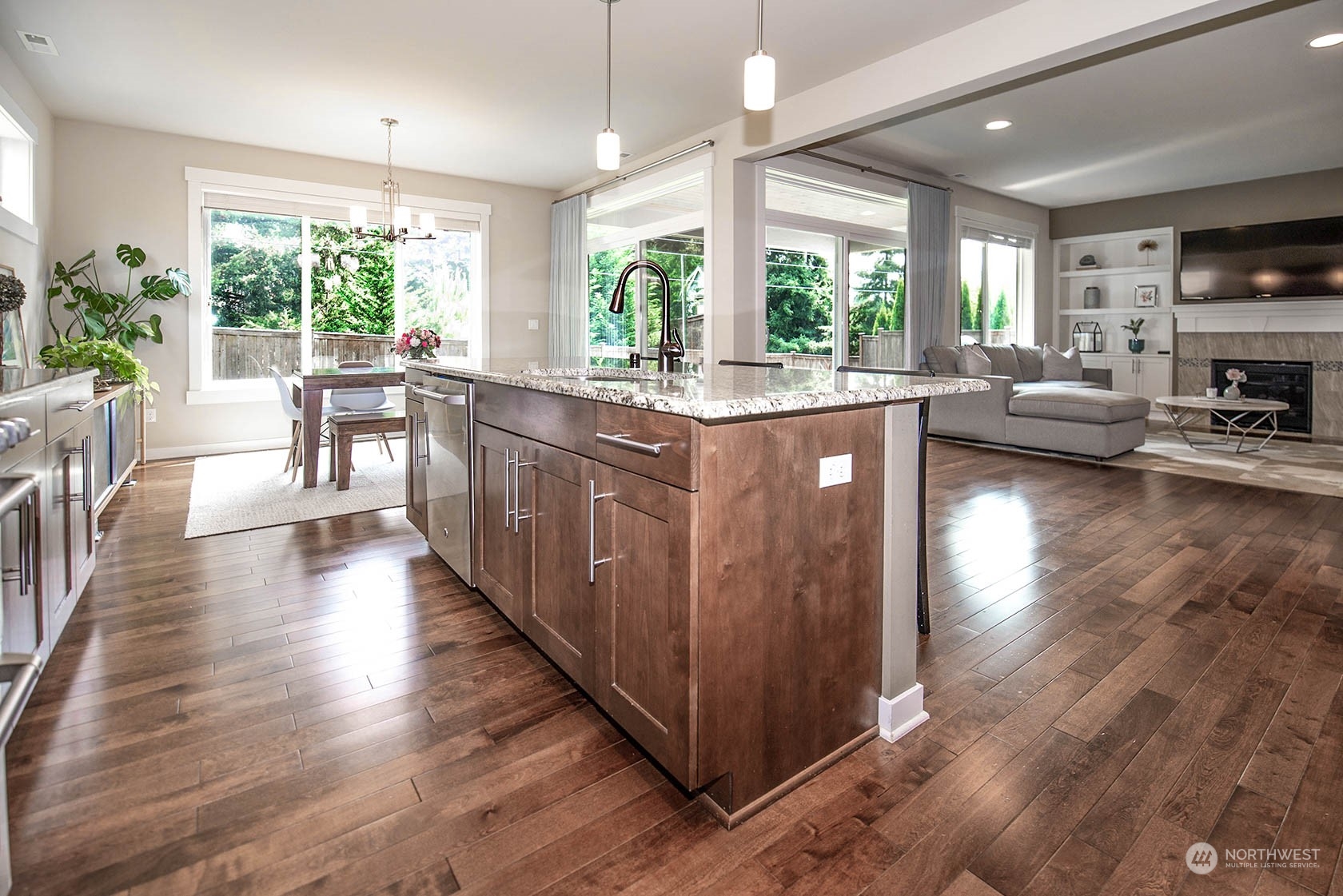 21127 35th Drive Southeast Bothell, WA 98021 - Photo 13 of 40 a kitchen with kitchen island granite countertop a stove a sink a dining table and chairs with wooden floor