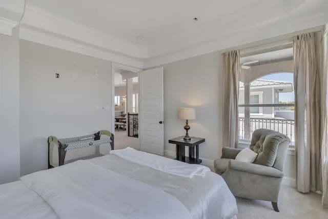 a bedroom with a bed and a potted plant on dresser