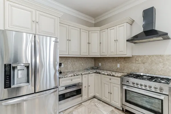 a kitchen with white cabinets and a window