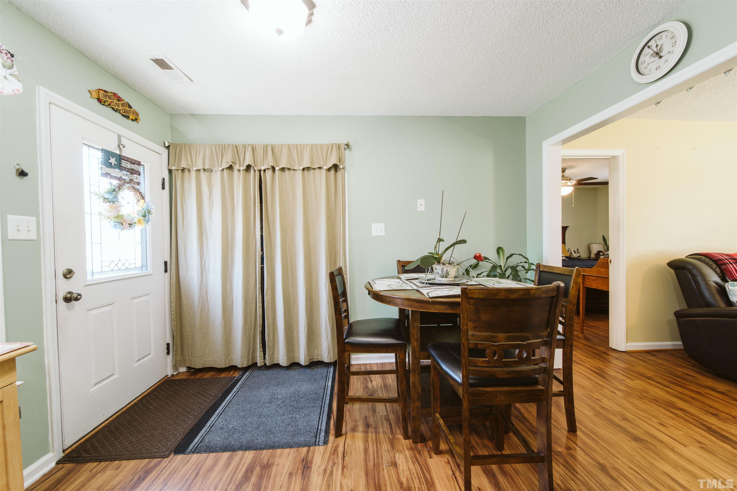 1283 Lee Road Clayton, NC 27520 - Photo 15 of 32 a view of a dining room with furniture and wooden floor