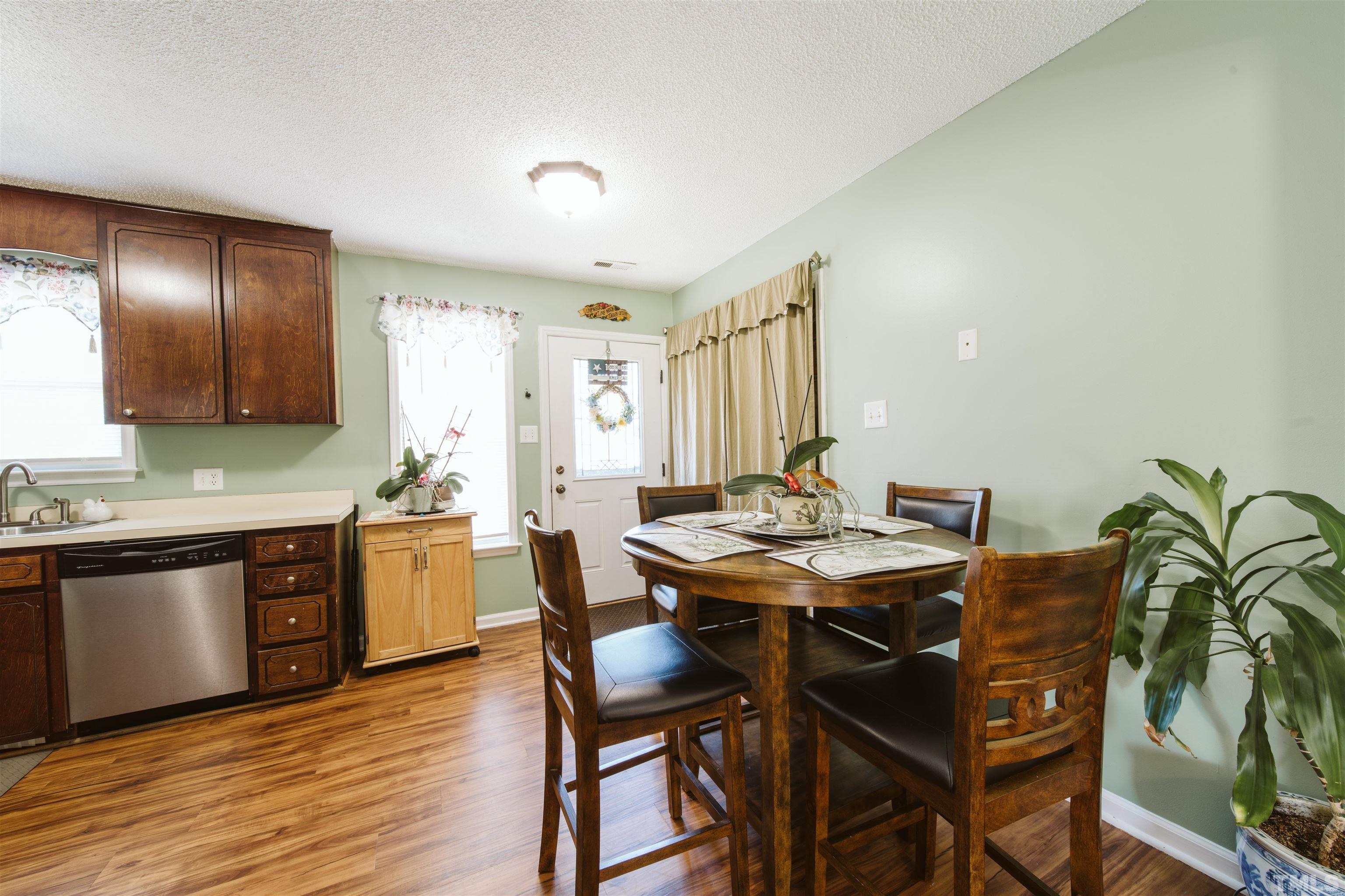 1283 Lee Road Clayton, NC 27520 - Photo 16 of 32 a view of a dining room with furniture and wooden floor