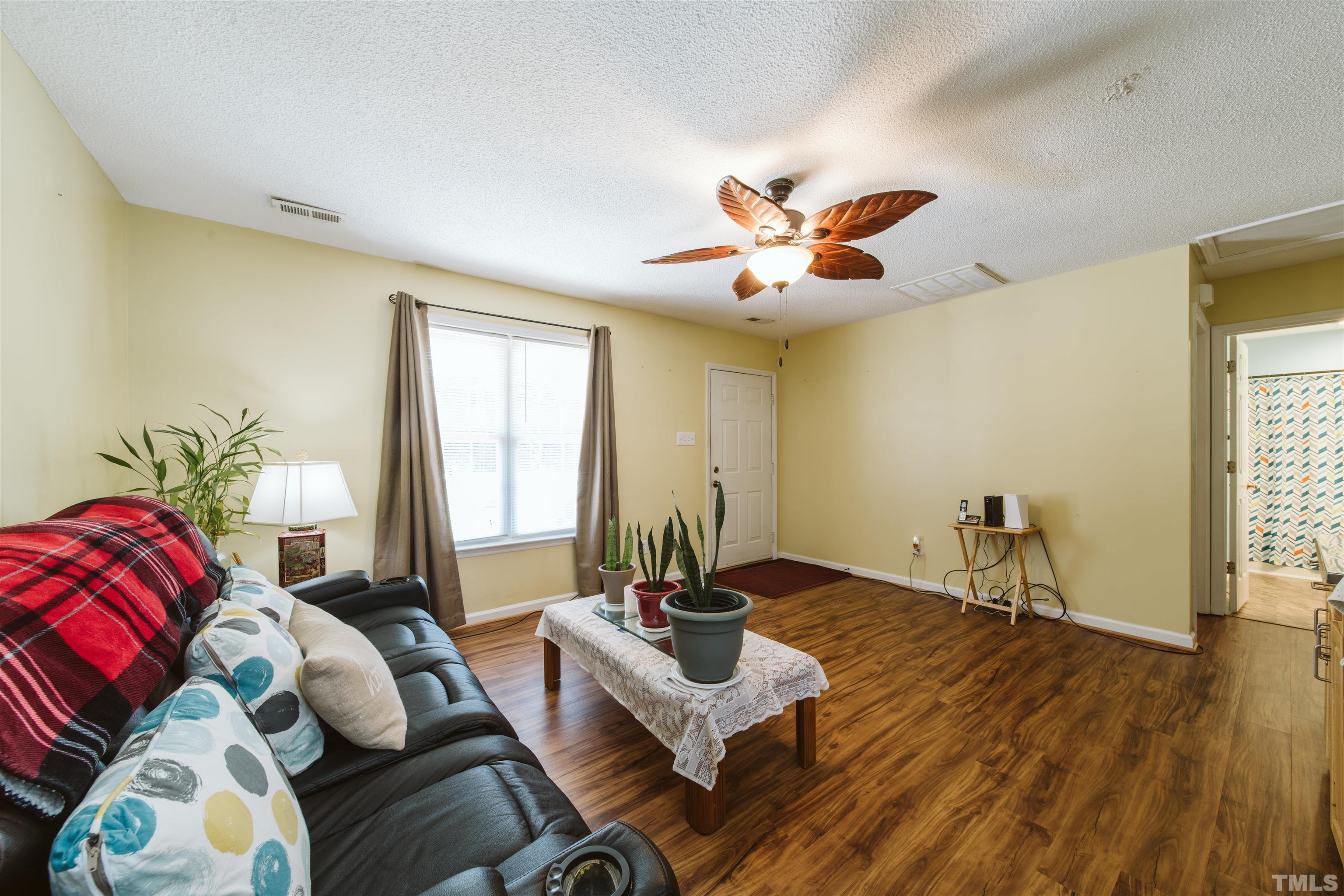 1283 Lee Road Clayton, NC 27520 - Photo 19 of 32 a living room with furniture chandelier and a window