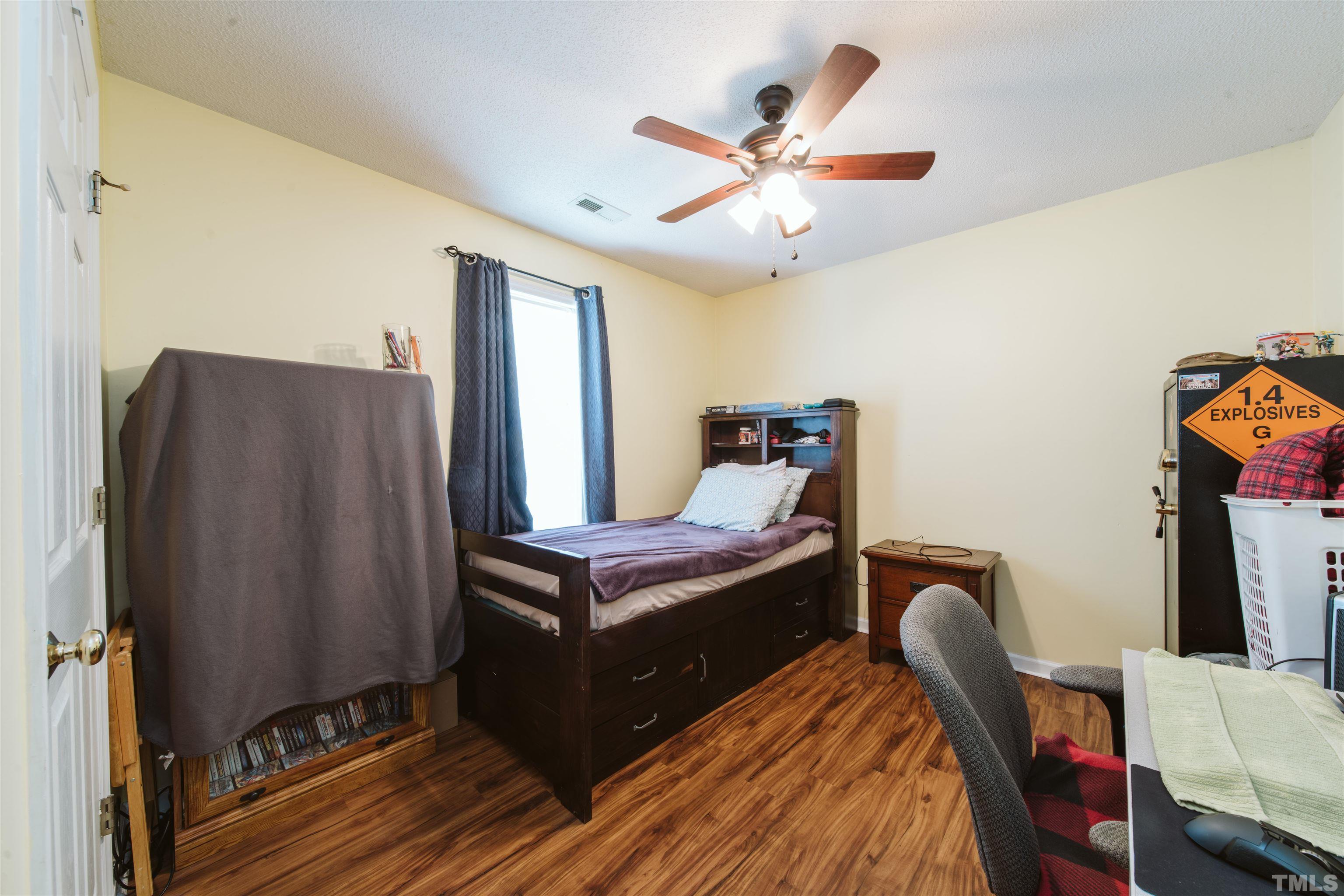 1283 Lee Road Clayton, NC 27520 - Photo 21 of 32 a bedroom with furniture and wooden floor
