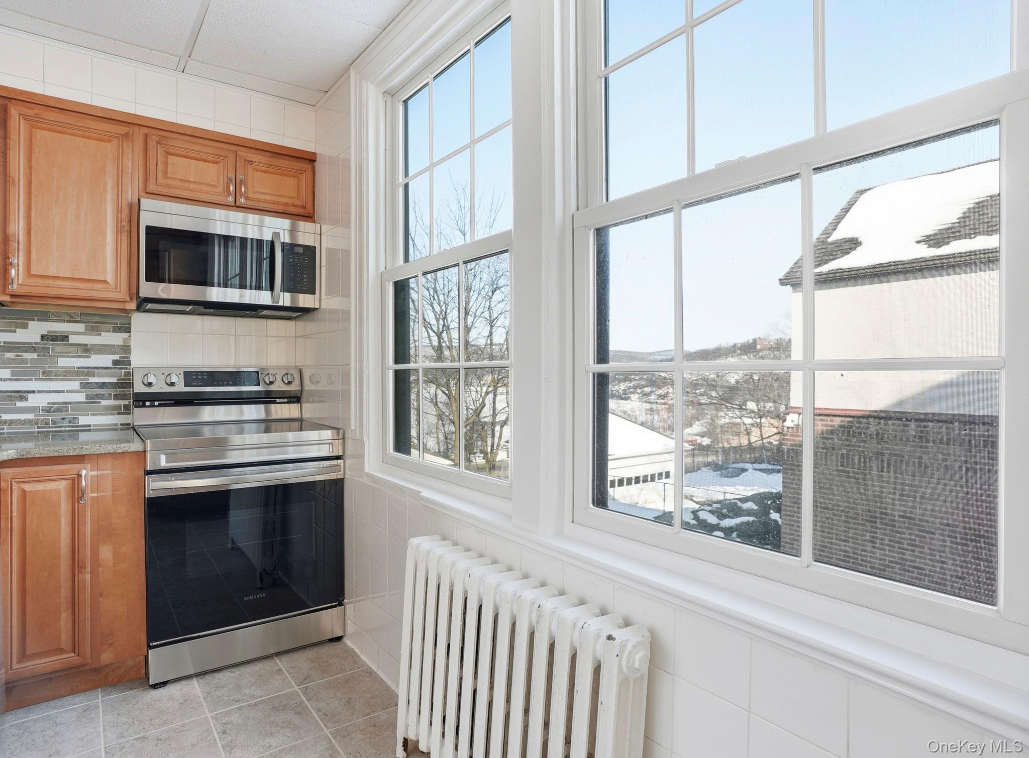 320 Simpson Place Peekskill, NY 10566 - Photo 11 of 18 a kitchen with stainless steel appliances a stove and a microwave