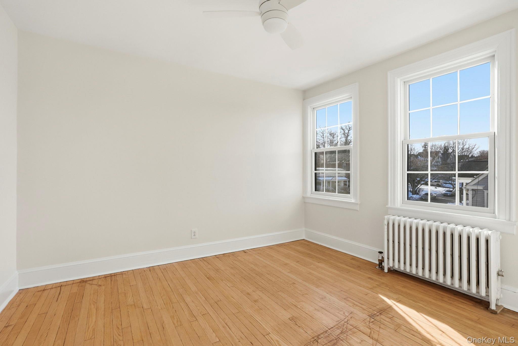 320 Simpson Place Peekskill, NY 10566 - Photo 15 of 18 an empty room with wooden floor and windows