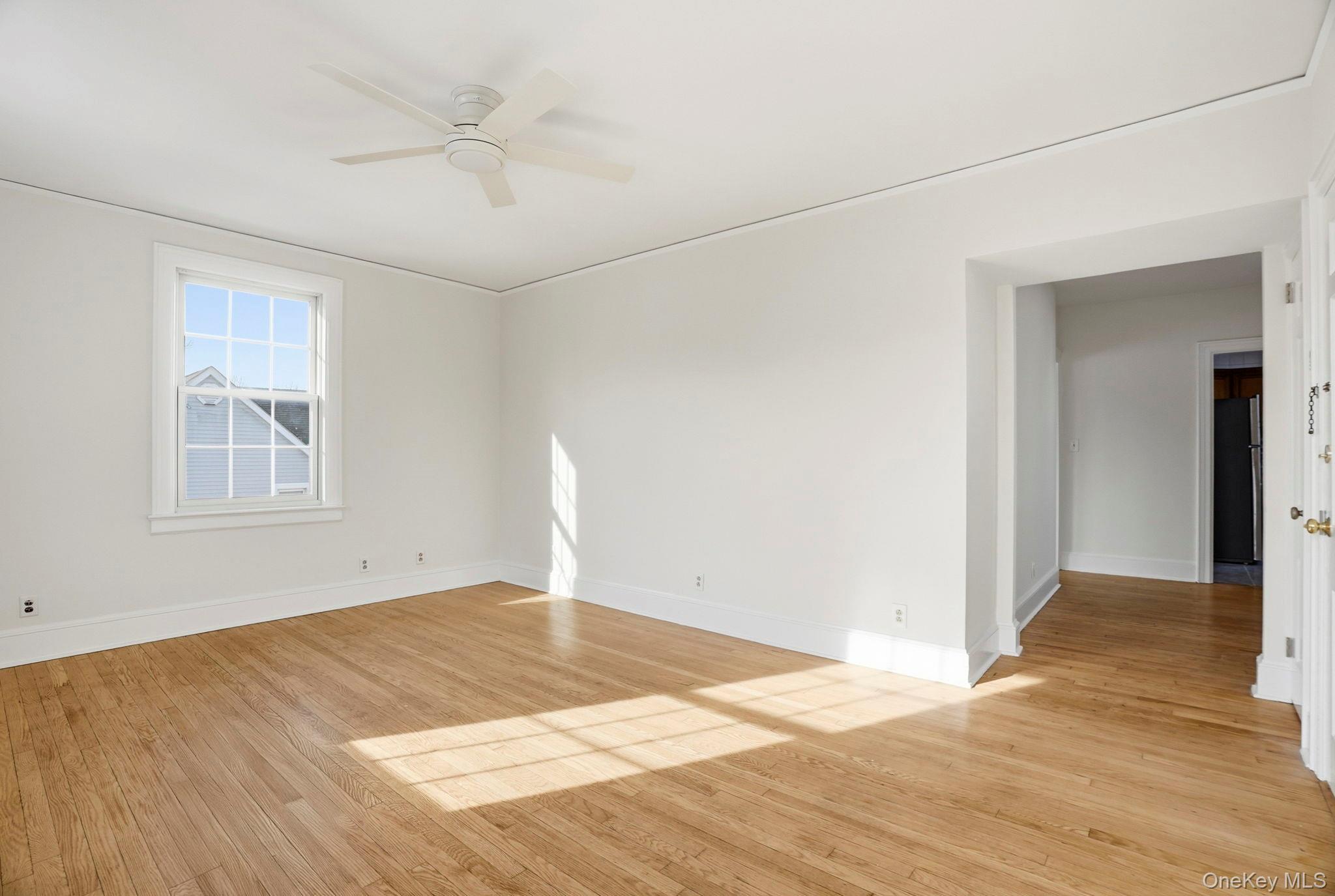 320 Simpson Place Peekskill, NY 10566 - Photo 5 of 18 a view of an empty room with wooden floor and a window
