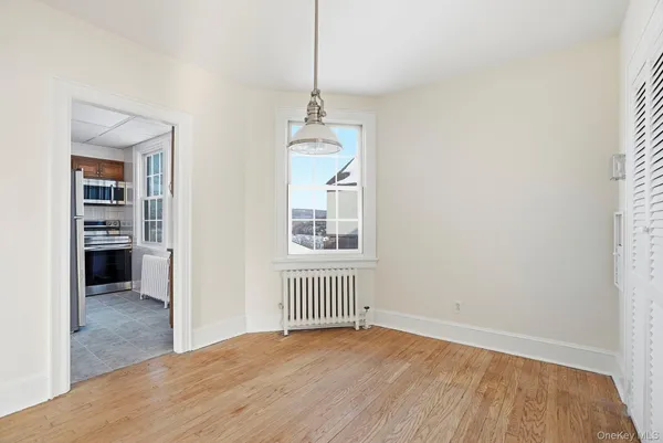 a view of a room with wooden floor and a window