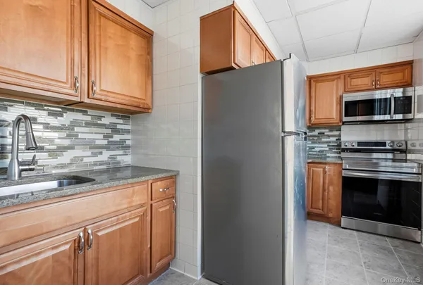 a kitchen with stainless steel appliances granite countertop a refrigerator and a stove top oven
