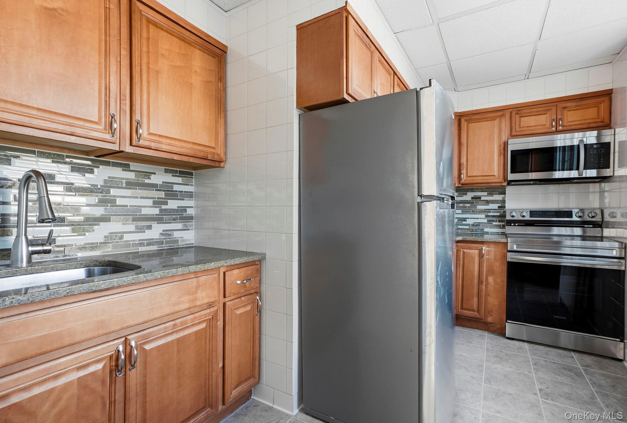 320 Simpson Place Peekskill, NY 10566 - Photo 10 of 18 a kitchen with stainless steel appliances granite countertop a refrigerator and a stove top oven