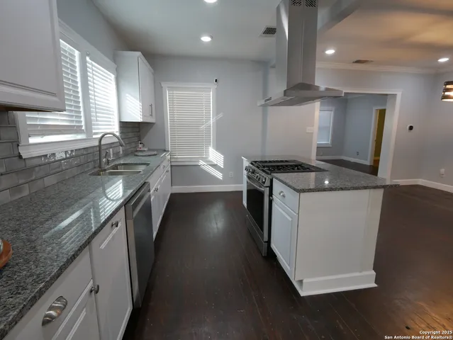 a kitchen with stainless steel appliances granite countertop a stove a sink and a refrigerator