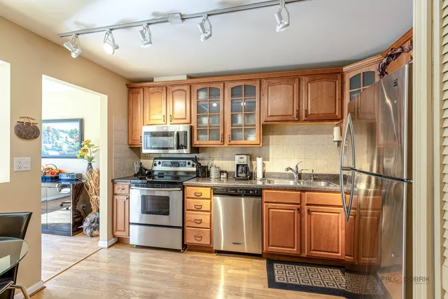 a kitchen with stainless steel appliances granite countertop a refrigerator a stove and a sink
