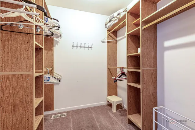 a view of walk in closet with clothes and shoes