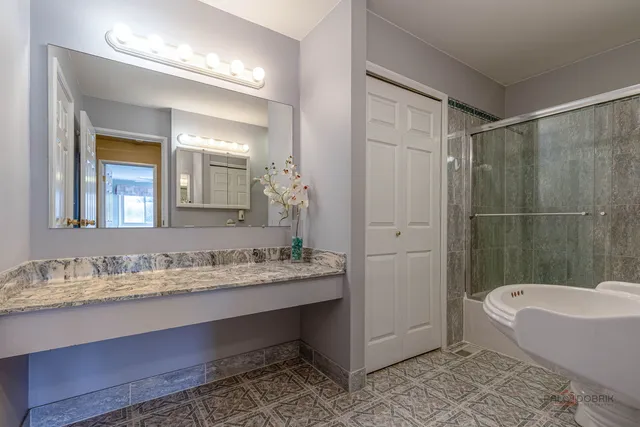 a bathroom with a granite countertop sink tub and a mirror