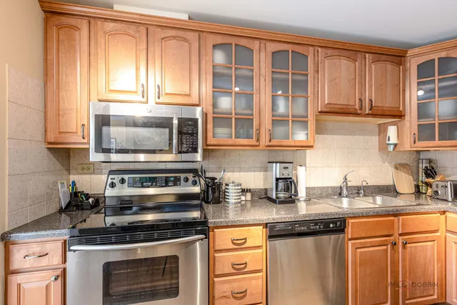 a kitchen with granite countertop a stove a sink and a microwave