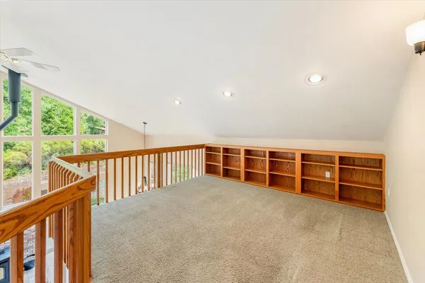 a view of an empty room with wooden floor and windows