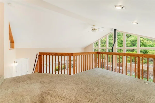 an empty room with windows and fan