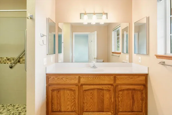 a bathroom with a granite countertop sink and a mirror