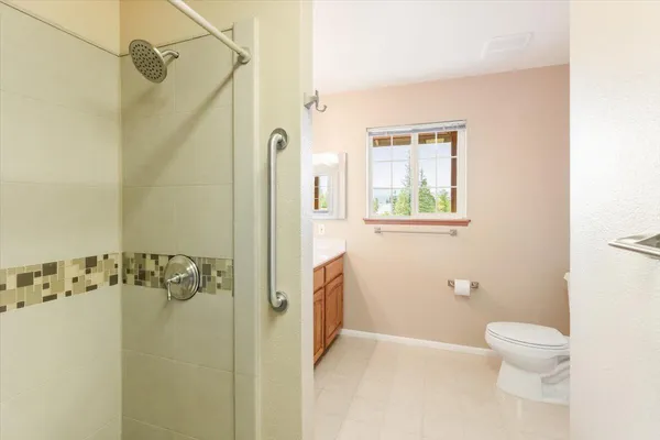 a bathroom with a granite countertop shower a toilet and a shower